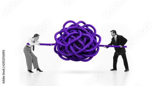 Obraz na płótnie Business partners pulling purple tangled rope in problem solving metaphor
