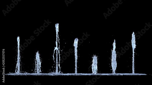 Isolated Line of 7 Tiny Trickle Fountains rising straight upwards on a black background