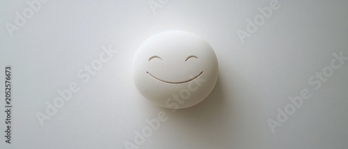 White round object with carved smiley face simple background clean minimalist design