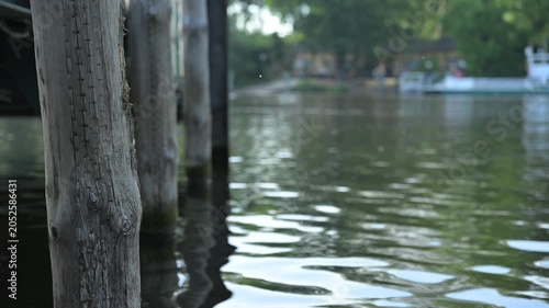 8-second static high-quality video featuring wooden dock posts, a lantern, and gentle water reflections along a peaceful riverside setting.