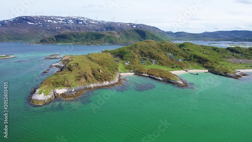 Aerial views capture the vibrant houses of Sommaroy, surrounded by clear waters and stunning fjord landscapes during summer. Discover nature beauty.