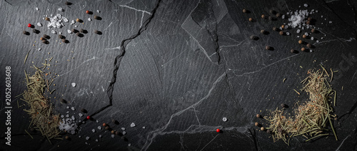 Spices, sea salt and rosemary on dark slate background with copyspace
