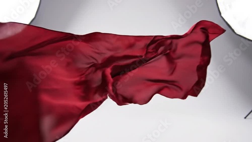 Red flowing silk fabric with elegant folds on white background