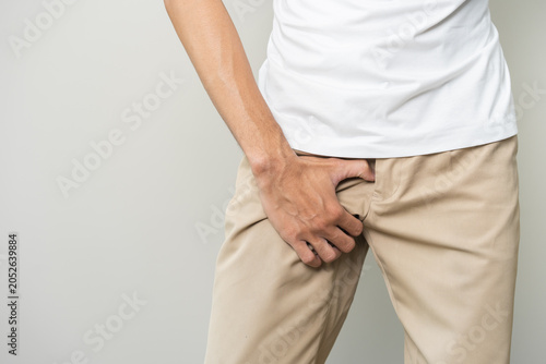 Foto Closeup annoying itch asian man with an itchy his jock and butt, male scratching crotch with his hand, itching groin, male suffering body problem