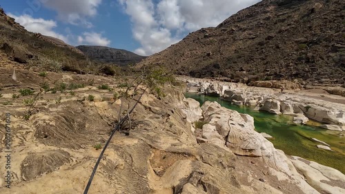 Rocky desert canyon with green water river. Sovotra, Yemen.