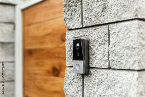Obraz na plátně Smart video doorbell camera mounted on a modern stone wall entrance
