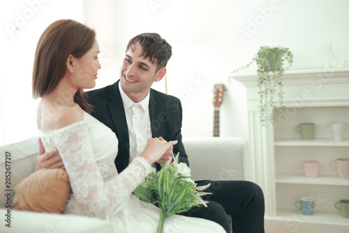 Fényképezés Married couple sits affectionately expressing their love and goodwill towards each other transgender woman and handsome foreign man sit holding hands gently demonstrating equality