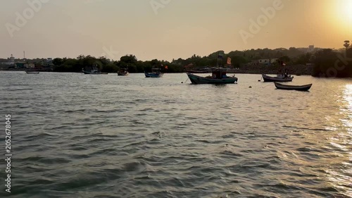 Small boats anchored near the river bank during a calm evening sunset