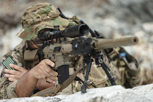Foto Military sniper aiming precision rifle during tactical reconnaissance mission in