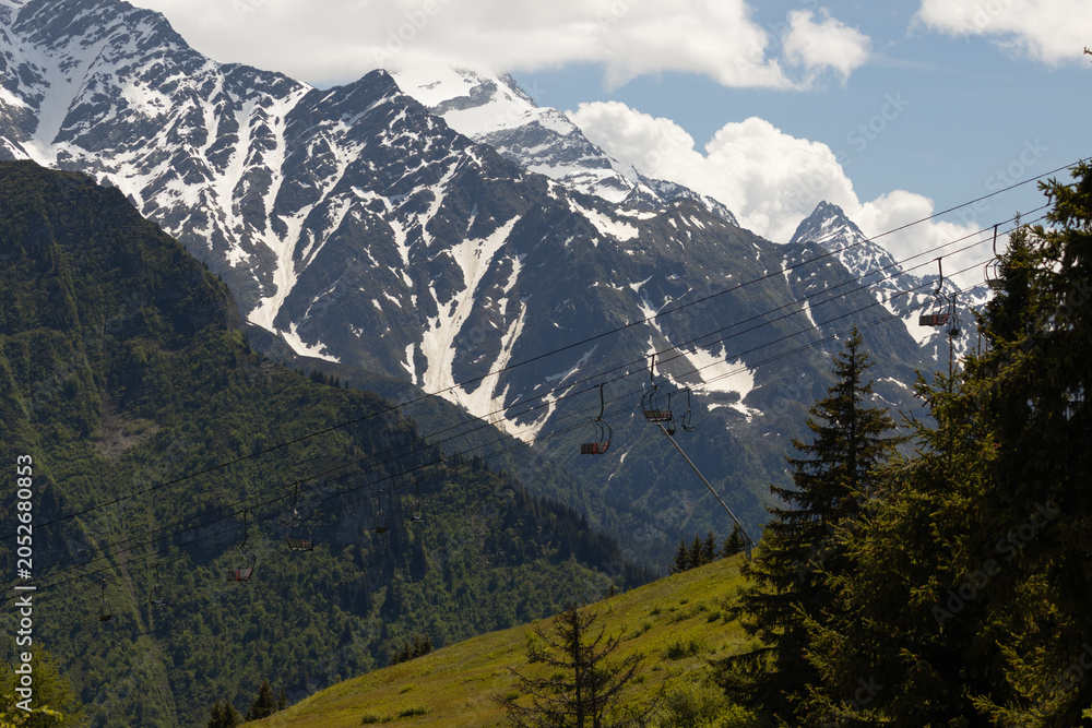 Fototapeta premium Empty Chairlifts Crossing a Summer Mountain Slope