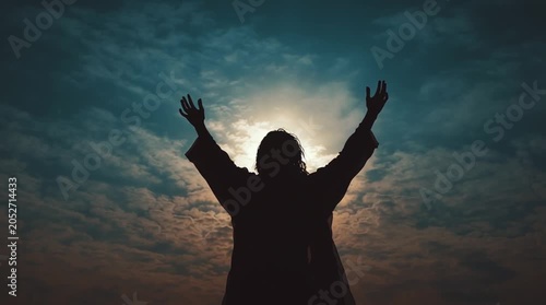 Silhouette of a person with arms outstretched towards the sun and sky