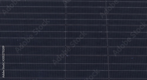 Closeup of a modern solar panel surface, showing the intricate grid pattern of photovoltaic cells and thin conductive busbars used for renewable energy generation and sustainable power technology