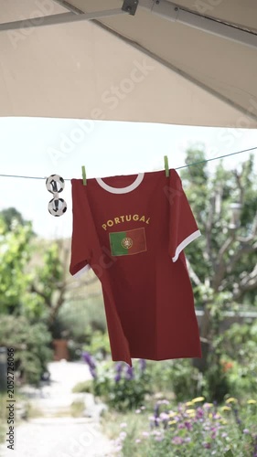 Portugal football supporter shirt with soccer sunglasses on clothesline, natural garden background blurred
