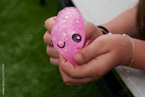 Canvastavla Child’s hand squeezing a pink glitter squishy dumpling toy