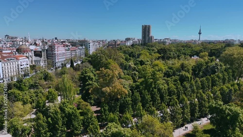 Wide drone shot of Retiro Park with Torrespaña and Madrid buildings beyond