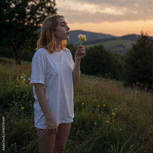 Woman Holding a Flower at Sunset in a Meadow