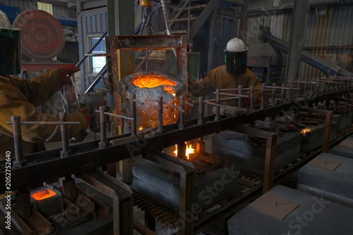 factory workers pouring molten metal