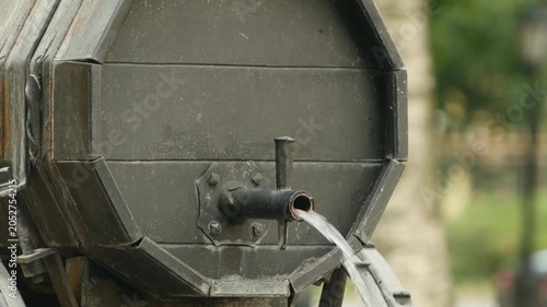 water pouring out of an old water carrier barrel, fountain