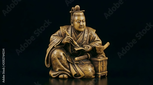 Traditional Japanese figure of man in samurai attire holding scroll  