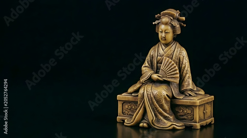 Bronze figurine of a geisha sitting with a fan on a pedestal  