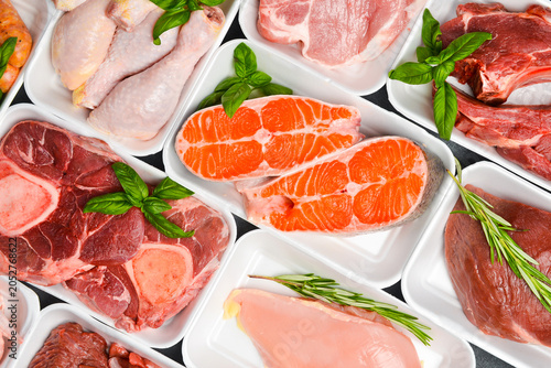 Various raw meat and fish in packaging trays from supermarket. Top view. Food background.