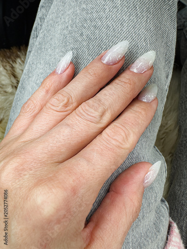 Fotografie Elegantly Styled Long Nails with a Glittering Ombre Effect on Denim-Clad Hand, S