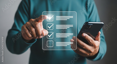 Digital Checklist Interaction: A man holds a smartphone and interacts with a glowing digital checklist interface, checking off tasks, representing modern task management and digital organization.