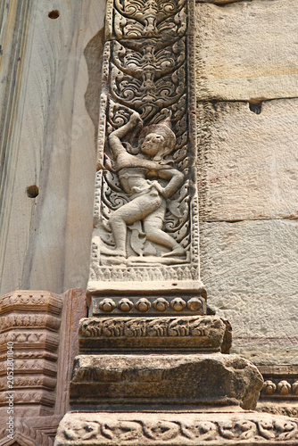Intricate carvings of traditional dancers and floral motifs on a stone door pillar at Phimai historical park, Nakhon Ratchasima, Thailand