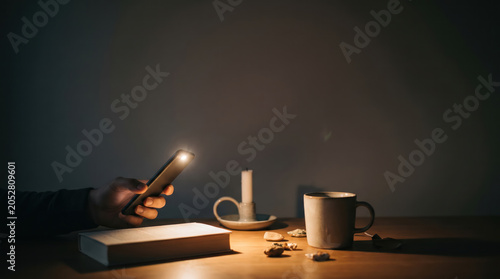 Smartphone Flashlight Illuminating Table During Home Power Outage