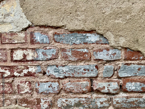 Obraz na plátně Old brick wall texture with peeling plaster and weathered surface