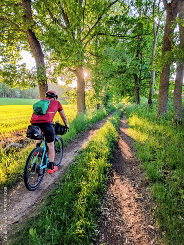 Man cyclist riding bicycle on gravel rural road