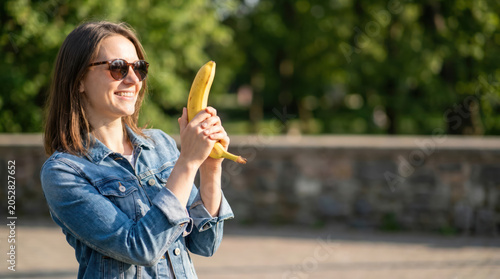 Smiling Woman Holding Banana Like a Toy Gun