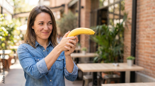 Smiling Woman Holding Banana Like a Toy Gun
