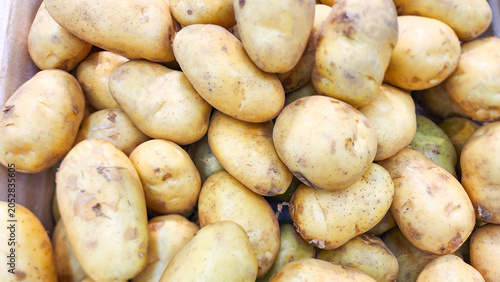 Fresh potatoes stacked at a local market, showcasing natural texture, earthy color, organic harvest, healthy ingredients, and agricultural produce ready for cooking and retail display.