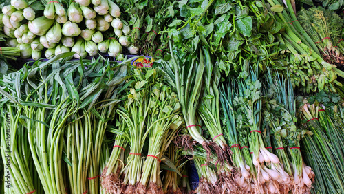 Fresh leafy vegetables and herbs displayed at a traditional market, featuring a variety of organic greens harvested for healthy cooking, local produce, and natural food ingredients.