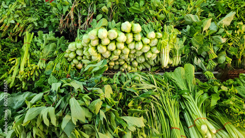 Fresh leafy vegetables and herbs displayed at a traditional market, featuring a variety of organic greens harvested for healthy cooking, local produce, and natural food ingredients.