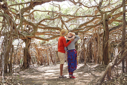 Romantic couple embracing while admiring the magical giant banyan tree grove