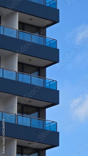 Modern building balconies reaching up to blue sky