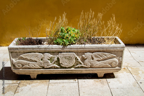 Stone flower pot with an ornament depicting dragons in Skradin town