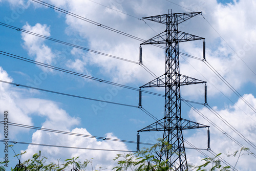 Cuadro en lienzo ** Tall Electrical Transmission Tower Against a Blue Sky with White Clouds and G