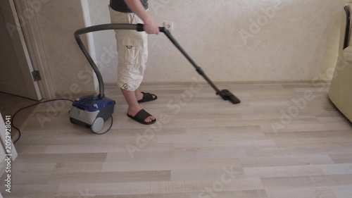Homeowner deep cleans. Vacuuming Floor with care. Person utilizes suction for thorough floor sanitation. Individual employs strategic vacuuming techniques for spotless floor appearance