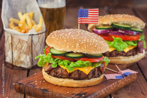 American Burger with bacon, cheese, tomato, lettuce and french fries at a Picnic for 4th of July