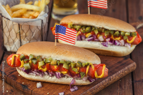 American hot dog with pickles, onions, ketchup, mustard and french fries at a Picnic for 4th of July