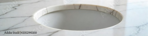 Close-up of a perfectly round, deep hole in pristine, polished marble, subtly lit to highlight its depth and texture, exuding an air of elegant simplicity and unexpected luxury , modern, white