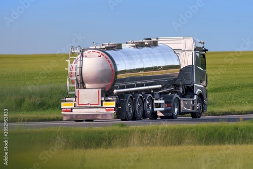 White tanker truck transporting liquid on highway road