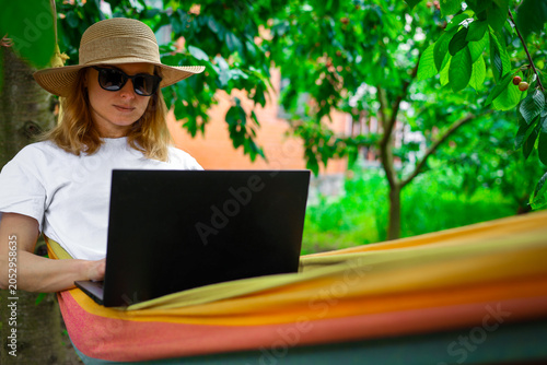 Quadro em tela Young woman using laptop outdoor