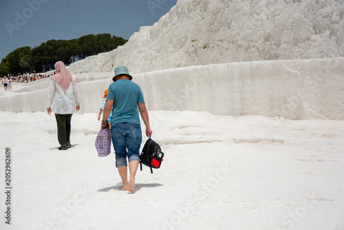 Visitors Exploring Pamukkale’s White Travertine Terraces in Bright Sunlight