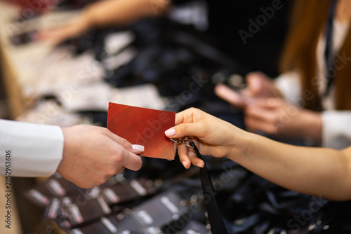 Close-up of Handing Over a Red Badge or Pass at a Registration Desk