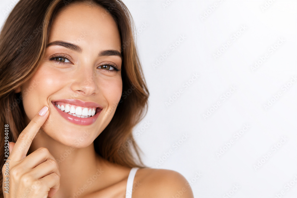 Naklejka premium Young woman pointing at smile in white studio portrait