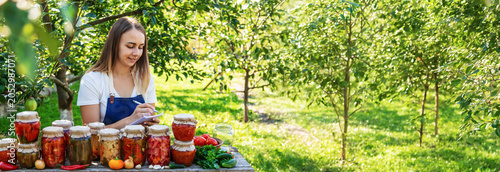 Fotografi woman canning tomatoes cucumbers vegetables on the background of nature